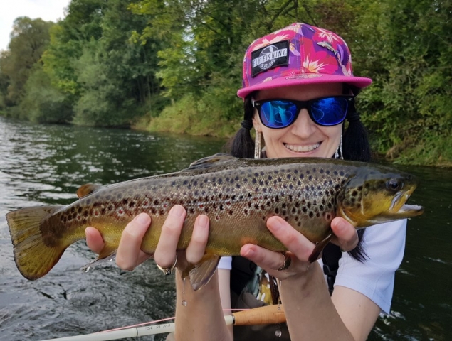 Happy angler with Brown Trout, girl fly fishing,