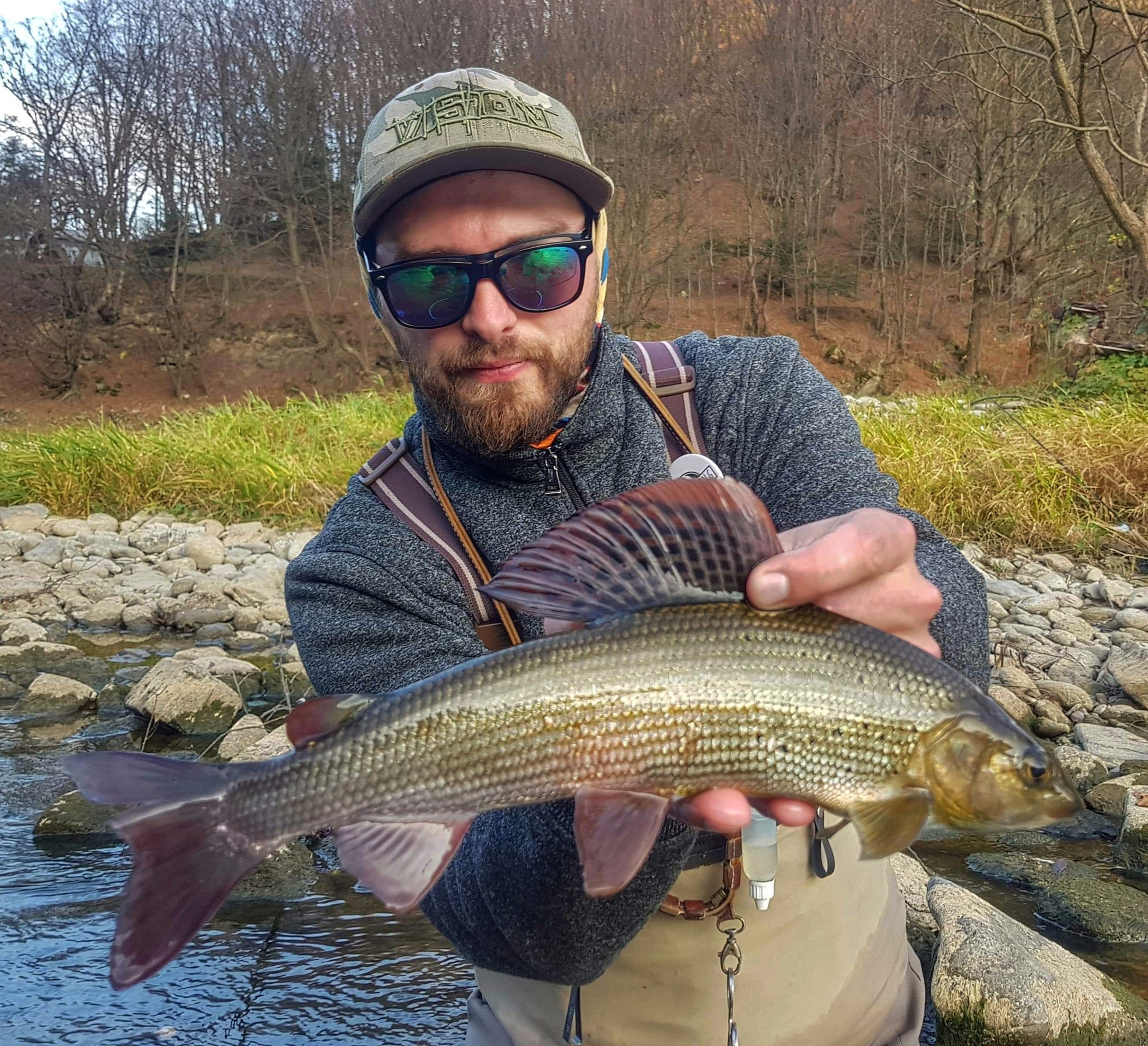 Fly fishing guide with nice grayling cought with small nymph